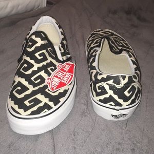 Pair of white & black vans w/ a zig zag pattern.